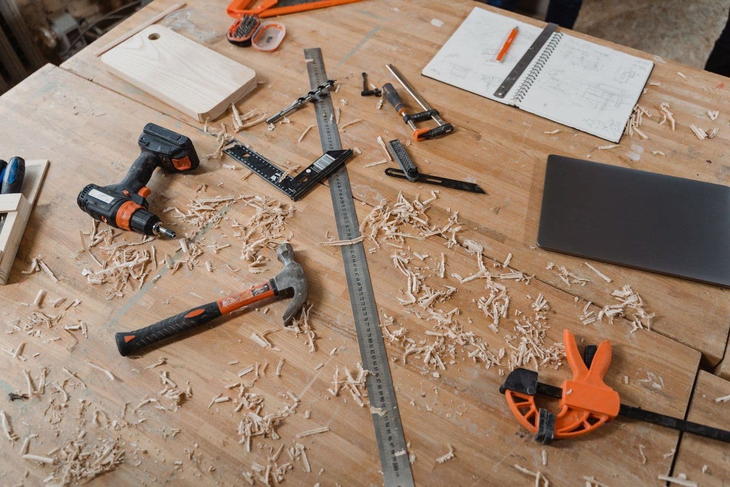 A carpenter's workbench with hand tools, a square, and sawdust