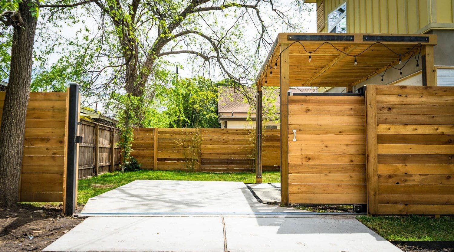 A new cedar privacy fence and pergola in a backyard