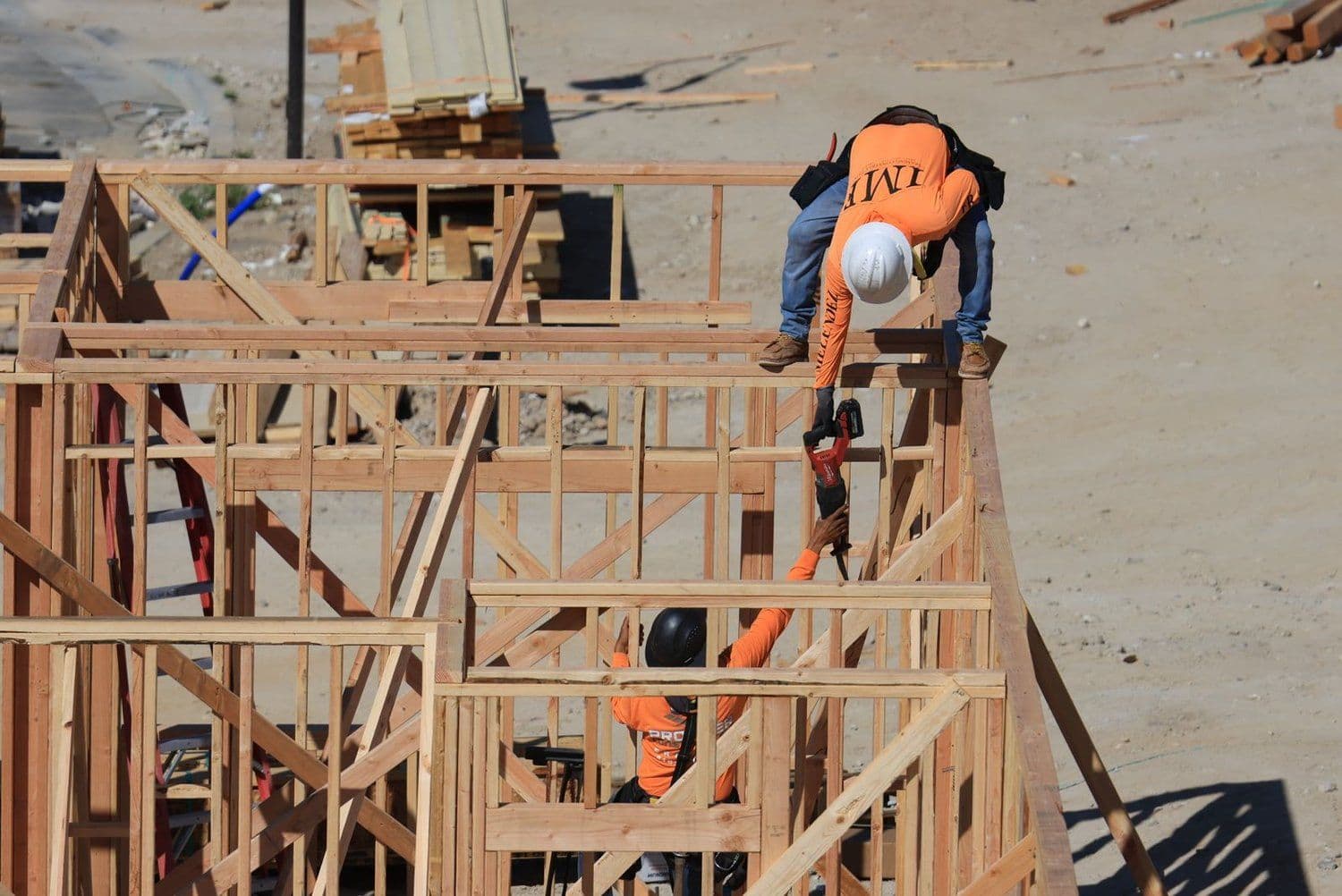 Carpenters framing a wall with wood studs